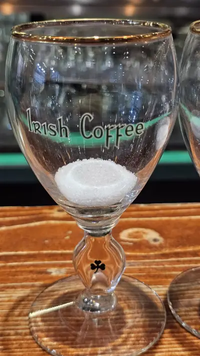 Een glas Irish Coffee op de houten toog
